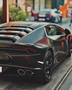 Sleek luxury sports car parked in vibrant Dubai street, showcasing modern design and elegance.